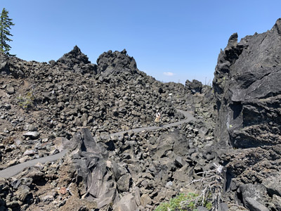 McKenzie River, Oregon, hiker dwarfed by lava flows